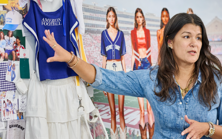 A person stands in front of a wall covered in fabric pieces and color swatches, including  blue cloth with text reading 