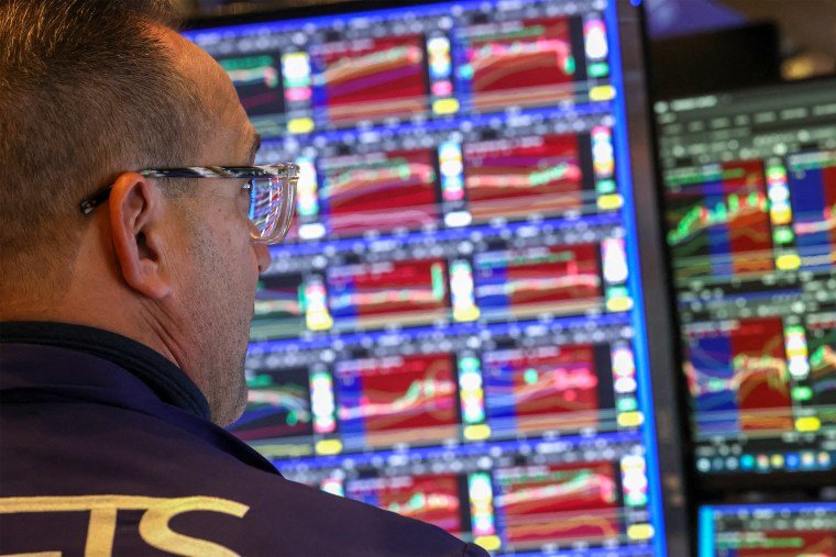 Image: A trader works at his desk on the floor of the New York Stock Exchange