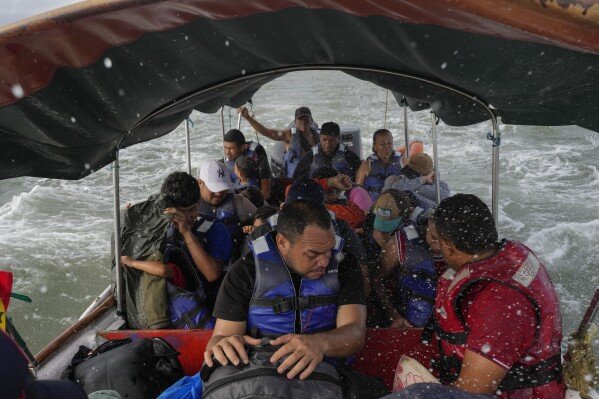 Luis Sanchez, center, rides on a boat with other Venezuelan migrants after giving up hopes of reaching the U.S. amid President Trump's crackdown on migration, on Feb. 23, 2025, near Gardi Sugdub, along Panama's Caribbean coast. (AP Photo/Matias Delacroix)