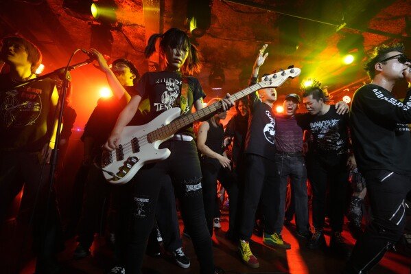 Fans join the Chinese punk rock band Gum Bleed as they perform during a music festival in Hangzhou, China, Jan. 17, 2025. (AP Photo/Aaron Favila)