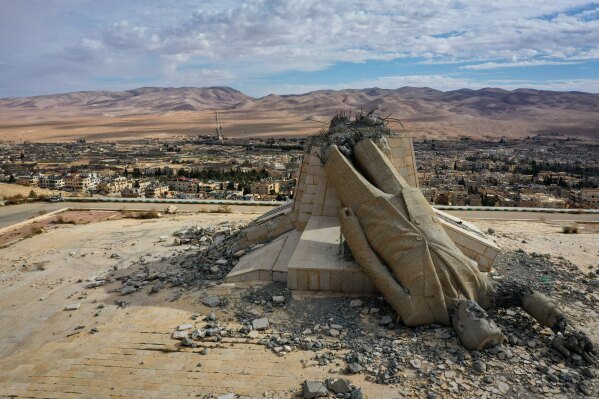A statue of the late Syrian President Hafez Assad, which was toppled and defaced during the overthrow of the Assad regime, lies in ruins atop a mountain in Dayr Atiyah, Syria, Jan. 5, 2025. (AP Photo/Ghaith Alsayed)