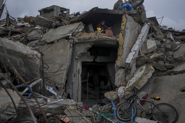Mohammad Naser takes cover from the rain in the ruins of his house, which was destroyed in an Israeli offensive, in Jabaliya, Gaza Strip, on Feb. 6, 2025. (AP Photo/Abdel Kareem Hana)