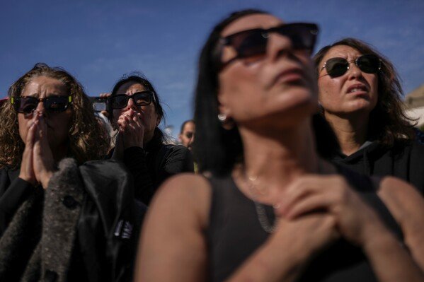 People watch a live broadcast of the release of three Israeli hostages from Gaza during a gathering at Hostages Square in Tel Aviv, Israel, Feb. 15, 2025. (AP Photo/Oded Balilty)