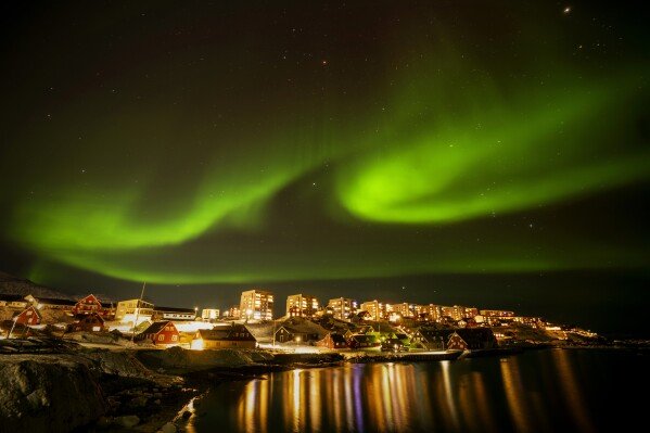 The Northern Lights shimmer over homes in Nuuk, Greenland, on Feb. 17, 2025. (AP Photo/Emilio Morenatti)
