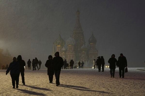 Snow falls on people walking through Red Square in front of St. Basil's Cathedral in Moscow as temperatures hover just below freezing on April 8, 2025. (AP Photo/Alexander Zemlianichenko)