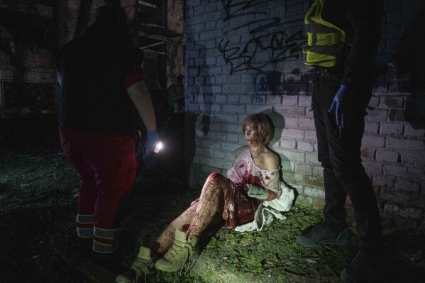 An injured woman sits near her house, which was damaged by a Russian airstrike, in a residential neighborhood in Kyiv, Ukraine, on April 24, 2025. (AP Photo/Evgeniy Maloletka)