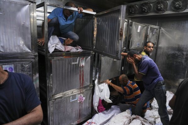 Bodies of Palestinians, who were killed while trying to reach aid trucks entering northern Gaza through the Zikim crossing with Israel, are prepared for burial at the morgue of Shifa Hospital in Gaza City on July 31, 2025. (AP Photo/Jehad Alshrafi)