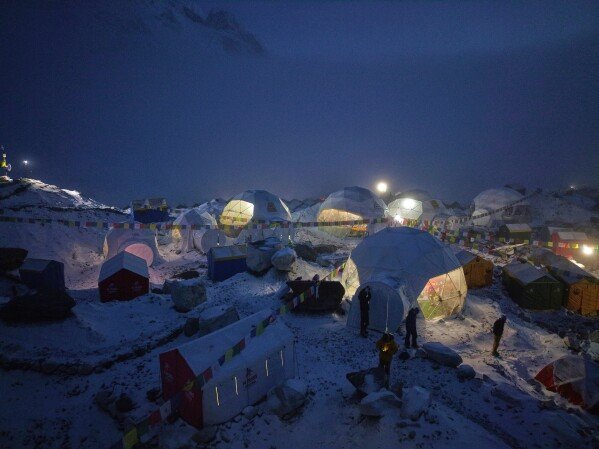 Members of an expedition to reach the summit of Mount Everest stand by their tents at the Everest Base Camp in Nepal on April 28, 2025. (AP Photo/Pasang Rinzee Sherpa)