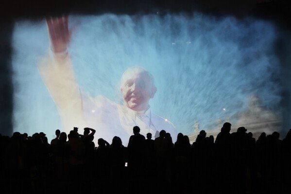 A portrait of the late Pope Francis is projected onto a water fountain at Magic Water Circuit in Lima, Peru, April 21, 2025. (AP Photo/Martin Mejia)