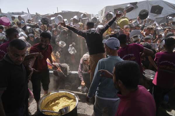 Palestinians struggle to get donated food at a community kitchen in Khan Younis, Gaza Strip, on May 16, 2025. (AP Photo/Abdel Kareem Hana)