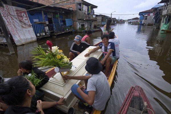 Friends and relatives of Jorge Luis Mendoza Cuelho, 14, ride with his coffin during his funeral in Belen, a district nicknamed the “Venice of the Jungle,” in Iquitos, Peru, on May 23, 2025. (AP Photo/Rodrigo Abd)