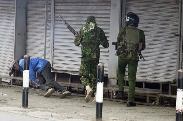 Street vendor Boniface Kariuki falls to the ground after he was shot in the head by a policeman, center, during a protest in Nairobi, Kenya, on June 17, 2025. (AP Photo/Brian Inganga)