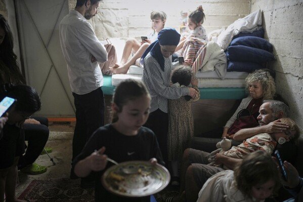Israelis take shelter in a Jerusalem basement during an Iranian missile strike on June 15, 2025. (AP Photo/Ohad Zwigenberg)