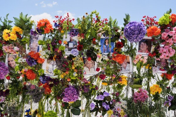 Photos of flood victims are displayed on a memorial wall in Kerrville, Texas, on July 10, 2025, a week after a catastrophic flood came barreling through the region, killing more than 130 people. (AP Photo/Ashley Landis)
