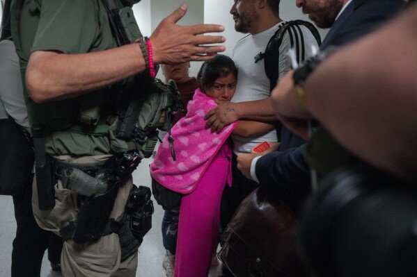 An asylum seeker from Ecuador hugs her father as he is detained by federal agents in New York on July 31, 2025. (AP Photo/Olga Fedorova)