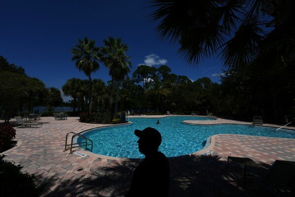 Luis, 30, who fled Venezuela after being an opposition political activist while at university, poses for a photo at the apartment complex where he lives in Orlando, Fla., on Aug. 19, 2025. An aspiring entrepreneur with a degree in mechanical engineering, Luis requested asylum in the U.S. and received a work permit which allows him to support himself as an Amazon delivery driver as he goes through the legal asylum process. (AP Photo/Rebecca Blackwell)