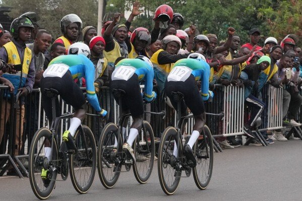 Rwanda's Eric Nkundabera, right, leads teammates Patrick Byukusenge and Mike Uwiduhaye during the team time trial mixed relay event at the road cycling World Championships in Kigali, Rwanda on Sept. 24, 2025. (AP Photo/Jerome Delay)