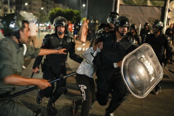 A boy is detained as youth-led protests calling for reforms to healthcare and education turn violent in Sale, Morocco, on Oct. 1, 2025. (AP Photo/Mosa'ab Elshamy)