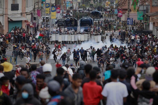 Demonstrators confront riot police during a protest against chronic cuts to electricity and water in Antananarivo, Madagascar, on Sept. 30, 2025. (AP Photo/Mamyrael)