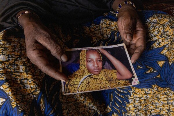Fatma holds a photo of her daughter who died when fleeing their Malian village, in Douankara, Mauritania, where Fatma has found refuge, Thursday, Nov. 6 2025. (AP Photo/Caitlin Kelly)