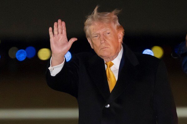 President Donald Trump waves as he arrives on Air Force One, Sunday, Jan. 4, 2026, at Joint Base Andrews, Md. (AP Photo/Alex Brandon)