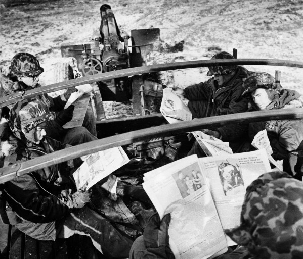 American troops in Germany read The Stars & Stripes during maneuvers, May 1962. (AP Photo)