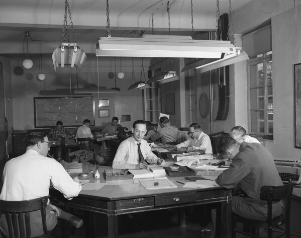 People work at the newsroom of The Stars & Stripes at Darmstadt, Germany, April 16, 1952. (AP Photo/Albert Riethausen)