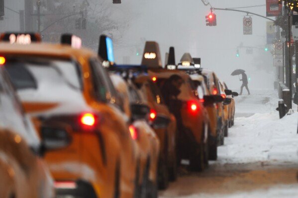 Pedestrians cross the street by Grand Central Station during a winter storm, Sunday, Jan. 25, 2026, in New York. (AP Photo/Heather Khalifa)