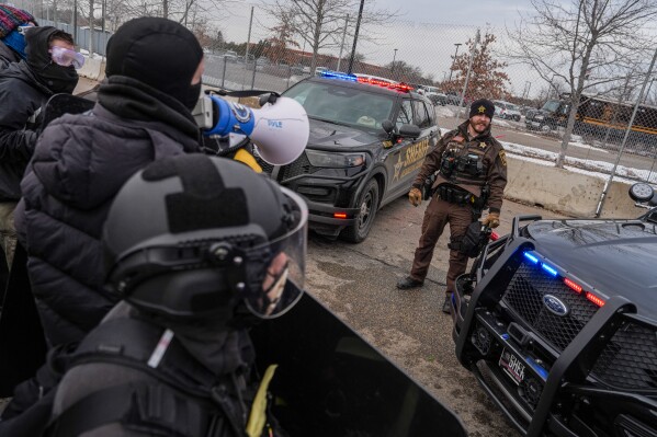 A Hennepin County Sheriff stands guard in front of protesters outside the Bishop Whipple Federal building in Minneapolis, Saturday, Feb. 7, 2026. (AP Photo/Ryan Murphy)