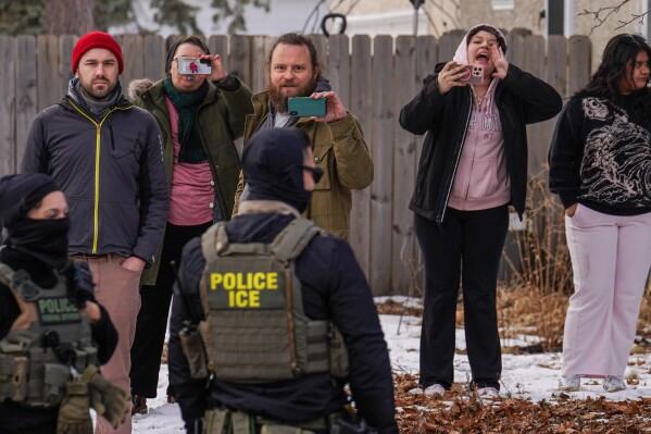 Observers film while federal agents conduct immigration enforcement operations, on Thursday, Feb. 5, 2026, in Minneapolis. (AP Photo/Ryan Murphy)