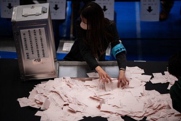 Election officials open ballot boxes as they prepare to count the votes in the lower house election in Tokyo, Sunday, Feb. 8, 2026. (AP Photo/Louise Delmotte)