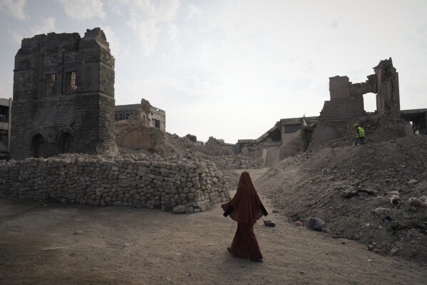 A Palestinian woman walks past the historic Pasha Palace in Gaza City after an Israeli airstrike badly damaged the building during the war in the Gaza Strip, Thursday, Nov. 13, 2025. (AP Photo/Jehad Alshrafi, File)