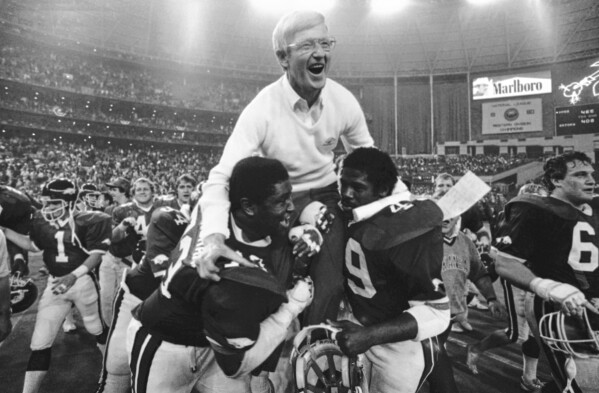 FILE - Arkansas coach Lou Holtz gets a victory ride on the shoulders of Earl Buckingham (73) and Milton Fields (49), after his Razorbacks defeated Florida in the Bluebonnet Bowl game, Dec. 31, 1982 in Houston. (AP Photo/File)