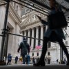 People walk by the New York Stock Exchange on Wall Street.