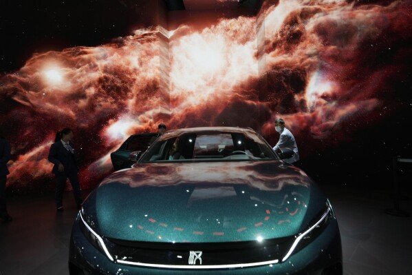 Attendees look at the electric Han EV sedan from Chinese automaker BYD during the Auto Shanghai 2023 show in Shanghai, Wednesday, April 19, 2023. (AP Photo/Ng Han Guan)