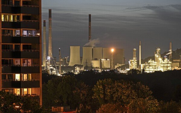 FILE - The coal-fired power plant Uniper Scholven and a nearby BP refinery shine in the evening behind illuminated appartments in Gelsenkirchen, Germany, Monday, Oct. 2, 2023. Environmental activists say the lobbying of fossil fuel interests are the reason why climate talks have yet to produce an agreement to phase out coal, oil and natural gas, as scientists have repeatedly said must happen to stave off the worst impacts of climate change, like extreme weather events. (AP Photo/Martin Meissner, File)