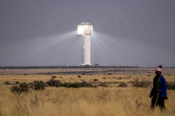A shepherd watches livestock near Khi Solar One, a solar thermal plant that converts the sun's light energy into electricity, outside Upington, South Africa, in the Northern Cape province, Friday, Aug. 29, 2025. (AP Photo/Themba Hadebe)