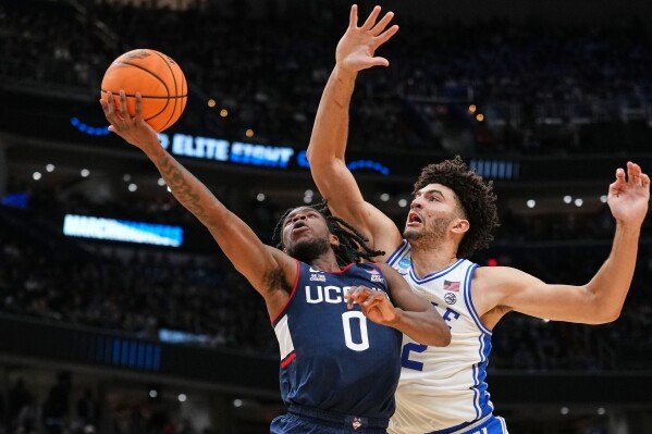 UConn guard Malachi Smith (0) shoots as Duke forward Cameron Boozer (12) defends during the second half in the Elite Eight of the NCAA college basketball tournament, Sunday, March 29, 2026, in Washington. (AP Photo/Abbie Parr)