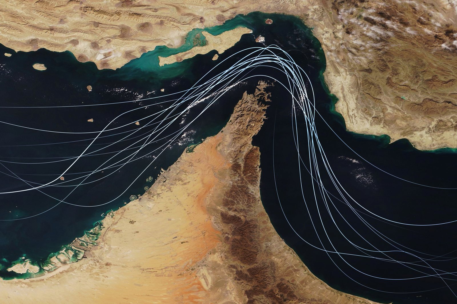 Satellite view of the Strait of Hormuz with white graphic lines representing global shipping lanes and maritime traffic between the Persian Gulf and Gulf of Oman