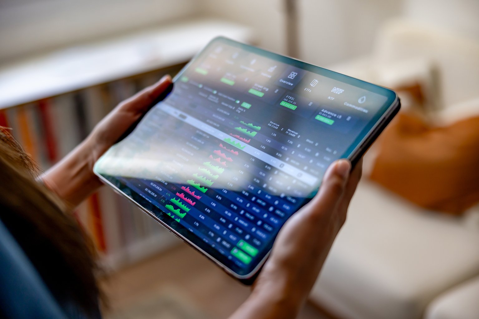 Woman at home investing in the stock market using an app on her tablet