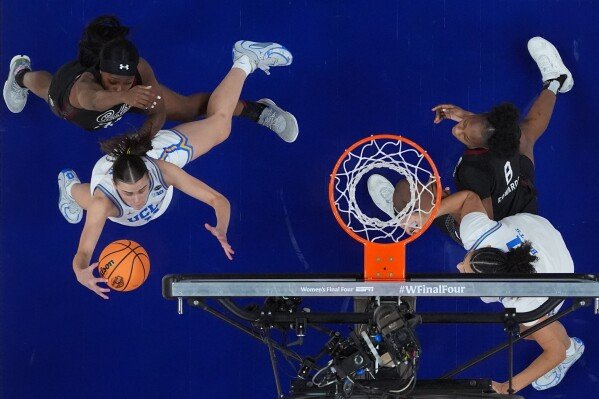 UCLA guard Gabriela Jaquez grabs a rebound over South Carolina guard Raven Johnson during the second half of the women's National Championship Final Four NCAA college basketball tournament game, Sunday, April 5, 2026, in Phoenix. (AP Photo/Ross D. Franklin)
