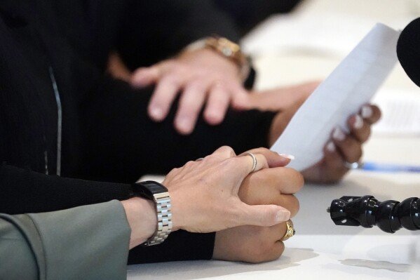 Two victims of UCLA gynecologist Dr. James Heaps hold hands during a news conference, May 24, 2022, in Los Angeles. (AP Photo/Marcio Jose Sanchez, File)
