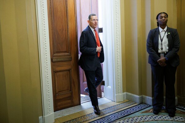 Senate Majority Whip John Barrasso, R-Wyo., exits his office following a meeting on Capitol Hill on Saturday, March 21, 2026, in Washington. (AP Photo/Tom Brenner)
