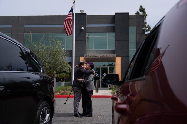 Milenko Faria, left, whose wife, Dr. Rubeliz Bolivar, is in immigration custody, hugs his attorney, Sonia Figueroa, after an asylum interview at the U.S. Citizenship and Immigration Services facility in Tustin, Calif., Thursday, April 16, 2026. (AP Photo/Jae C. Hong)