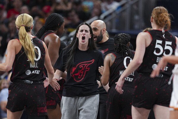 Indiana Fever guard Caitlin Clark celebrates with teammates as the Phoenix Mercury called a timeout in the first half of a WNBA basketball game in Indianapolis, July 30, 2025. (AP Photo/Michael Conroy, File)