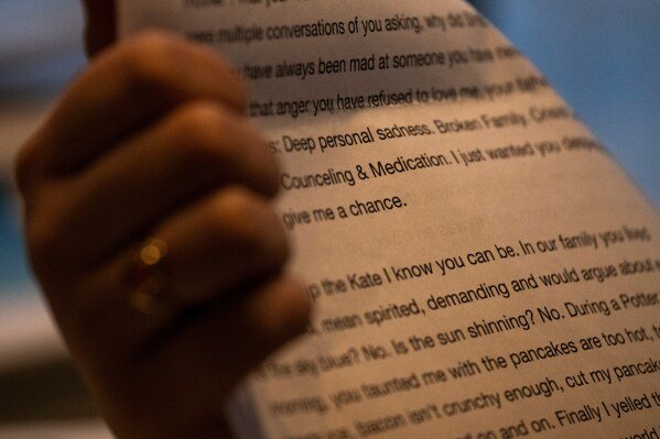 Kate goes through folders of writings and photographs from her time at Unita Academy and other treatment based camps in her apartment in Kentucky, Wednesday, December 10, 2025. (AP Photo/Michael Swensen)