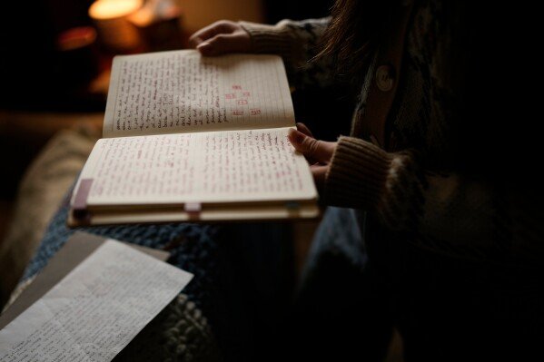 Zoie Albers reads through a journal at her home Saturday, Jan. 17, 2026, in Piperton, Tenn. (AP Photo/George Walker IV)