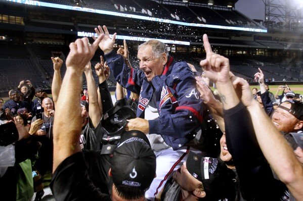 Atlanta Braves players lift manager Bobby Cox after they clinched the National League wild card in Atlanta, Oct. 3, 2010. (AP Photo/John Bazemore, File)