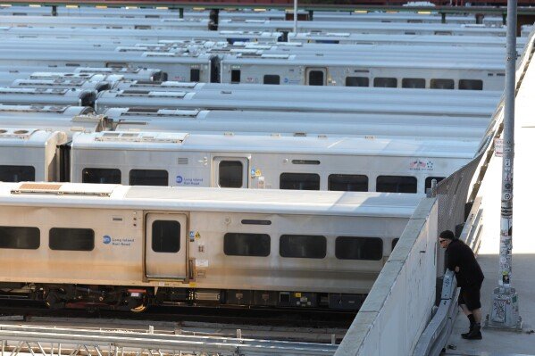 A pedestrian looks out at the trains at the West Side Yard on the first day of a Long Island Rail Road strike, Saturday, May 16, 2026, in New York. (AP Photo/Heather Khalifa)