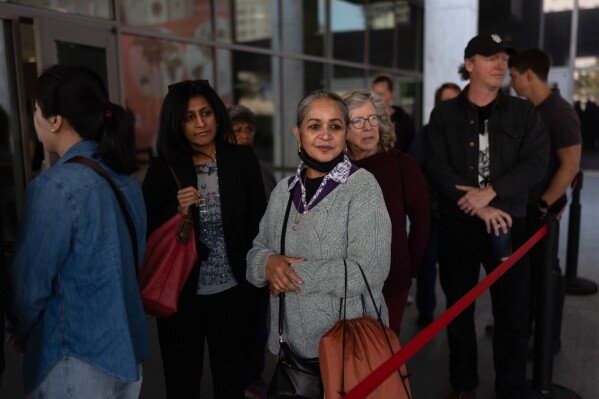 Masuma Khan, center, an immigrant from Bangladesh who was held at an immigration detention facility in California City the previous year, waits in line with her attorney, Laboni Hoq, left, to enter the federal building for an appointment in Los Angeles, April 21, 2026. (AP Photo/Jae C. Hong)